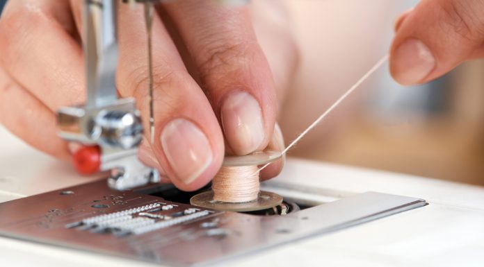 tailor threading a sewing machine seen from close up