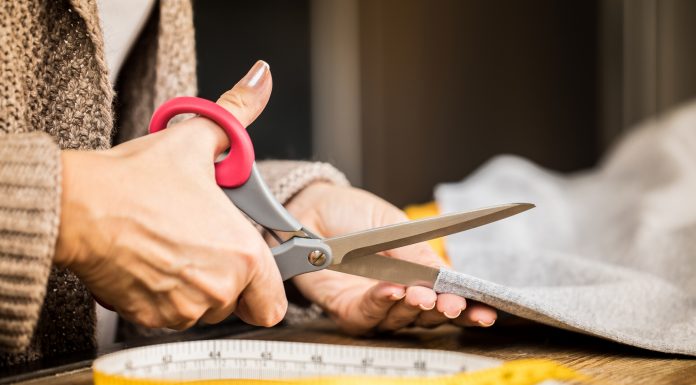 How to Cut Fabric with Precision – Best Tips woman cutting fabric with scissors